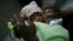 FILE - Three-day-old premature baby Jessica Thelusma is carried by her mother Silvie Estain in the emergency room at General Hospital in Port-au-Prince, Haiti.