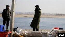 （资料照片）中国农民在中朝边境界河边卖鱼