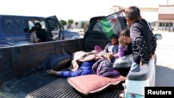 Civilians, who were wounded by what activists said was violence caused by Islamic State fighters in Kobani, wait with their relatives to cross into Turkey at the Syrian-Turkish border crossing of Tel Abyad, Syria June 25, 2015. 