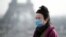 巴黎市埃菲尔铁塔前一名女子戴上口罩（路透社2020年1月25日）