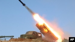 3月14日朝中社發佈的照片顯示兩個島嶼上的炮兵部隊在實彈演習中發射火箭。