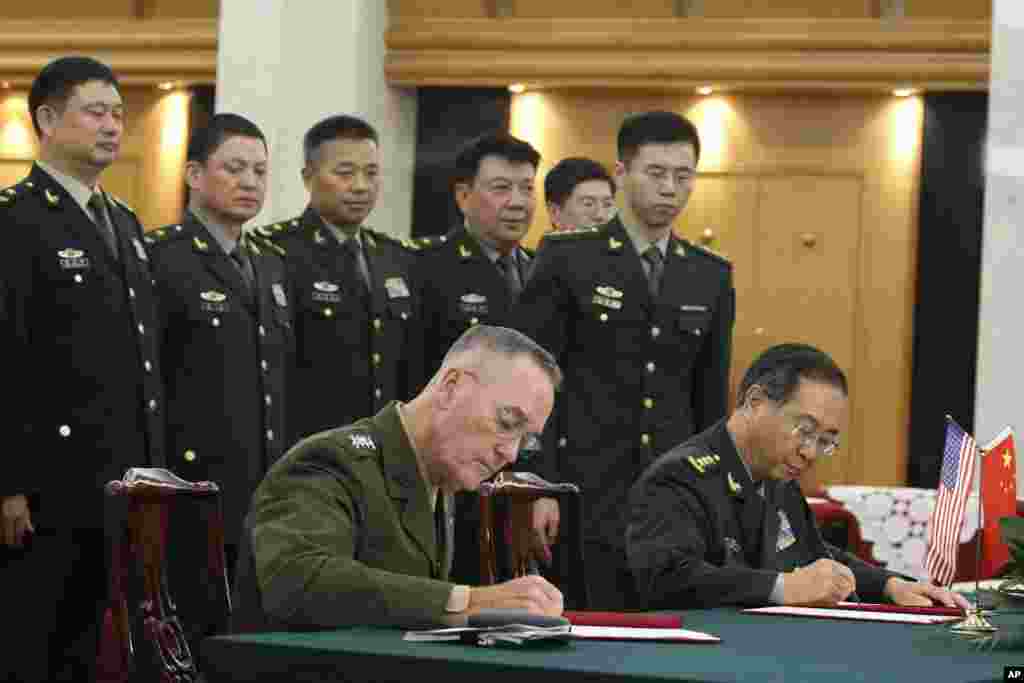 美军参联会主席邓福德上将（前左）与中国中央军委联合参谋部参谋长房峰辉在北京签署协议（2017年8月15日）。美国和中国高级军事将领在朝鲜导弹项目和中国在南中国海有争议申索造成局势紧张之际签署了加强两军通讯交流的协议。
