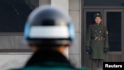 2011年12月28日朝鲜士兵(右)和韩国士兵(左)在两韩非军事区板门店停战村面对面站岗