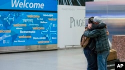 刚出关的一个13岁的也门男孩在纽约肯尼迪国际机场跟接机的父亲拥抱 (2017年2月5日)