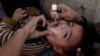 A boy receives polio vaccine drops by anti-polio vaccination workers along a street in Quetta, Pakistan, Jan. 2, 2017. 