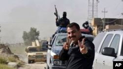 伊拉克特種部隊與伊斯蘭國武裝激戰後佔領費盧傑市中心，慶祝勝利的伊拉克戰士打成勝利的手勢。 （2016年6月17日）