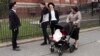 A woman, right, who identified herself as Ester, passes a group of boys, April 9, 2019, in the Williamsburg section of Brooklyn, New York. Ester says that she does not believe that the measles vaccination is safe.