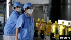 中國山東省曲阜市，糧油工業和進出口公司的工人檢查瓶裝豆油。這些豆油是用美國大豆提煉的。 （2018年7月4日）