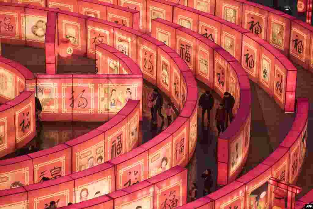 2018年2月14日，农历新年前夕，在陕西省西安市的大唐芙蓉园，人们走进迷宫。迷宫的墙壁上有各种字体的福字。