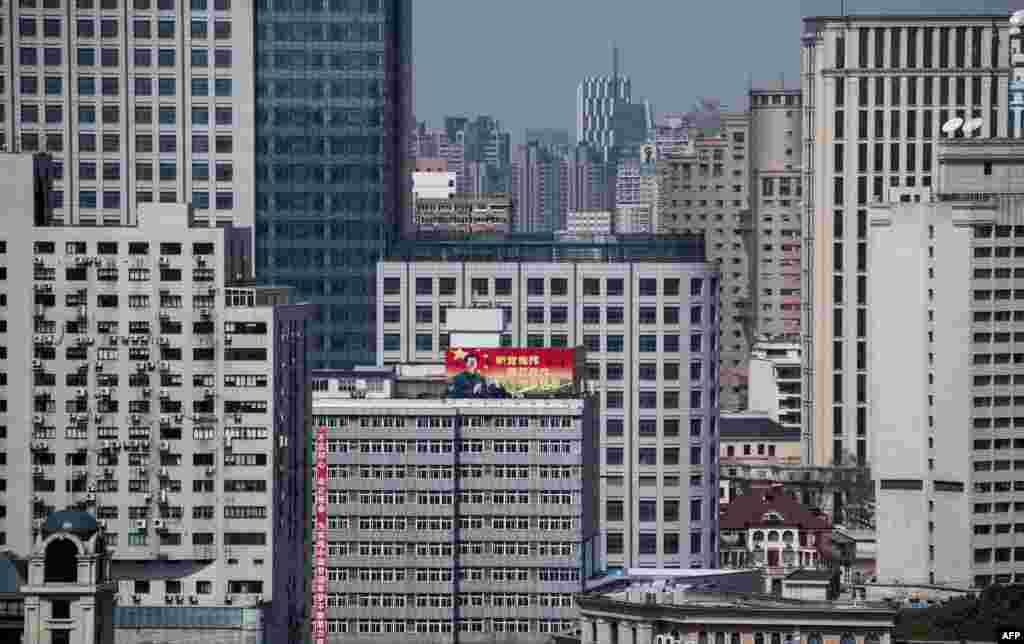 2018年3月12日，上海市中心的高层建筑，一座楼的顶部有展示中国国家主席习近平像和标语&ldquo;听党指挥 能打胜仗 作风优良&rdquo;的宣传海报，大楼也悬挂标语&ldquo;&ldquo;不忘初心 牢记使命 为实现中国梦强军梦不懈努力奋斗&rdquo;。