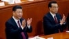 Chinese President Xi Jinping, left, and Chinese Premier Li Keqiang applaud during the opening session of the annual National People's Congress at the Great Hall of the People in Beijing, March 5, 2018.