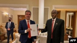 Aliyekuwa Waziri wa Usalama wa Taifa Eli Cohen (left) akibadilishana nyaraka na Waziri wa Ulinzi wa Sudan Ibrahim Yasin wakati walipokutana mjini Khartoum, Sudan January 25, 2021.