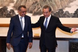 FILE - Tedros Adhanom Ghebreyesus, director general of the World Health Organization, left, attends a meeting with Chinese State Councilor and Foreign Minister Wang Yi at the Diaoyutai State Guesthouse in Beijing, Jan. 28, 2020.