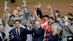 休斯顿太空人队老板吉姆·柯雷恩高举奖杯。（2017年11月1日）Houston Astros owner Jim Crane holds the championship trophy after Game 7 of baseball's World Series against the Los Angeles Dodgers, Nov. 1, 2017, in Los Angeles. The Astros won 5-1 to win the series 4-3.
