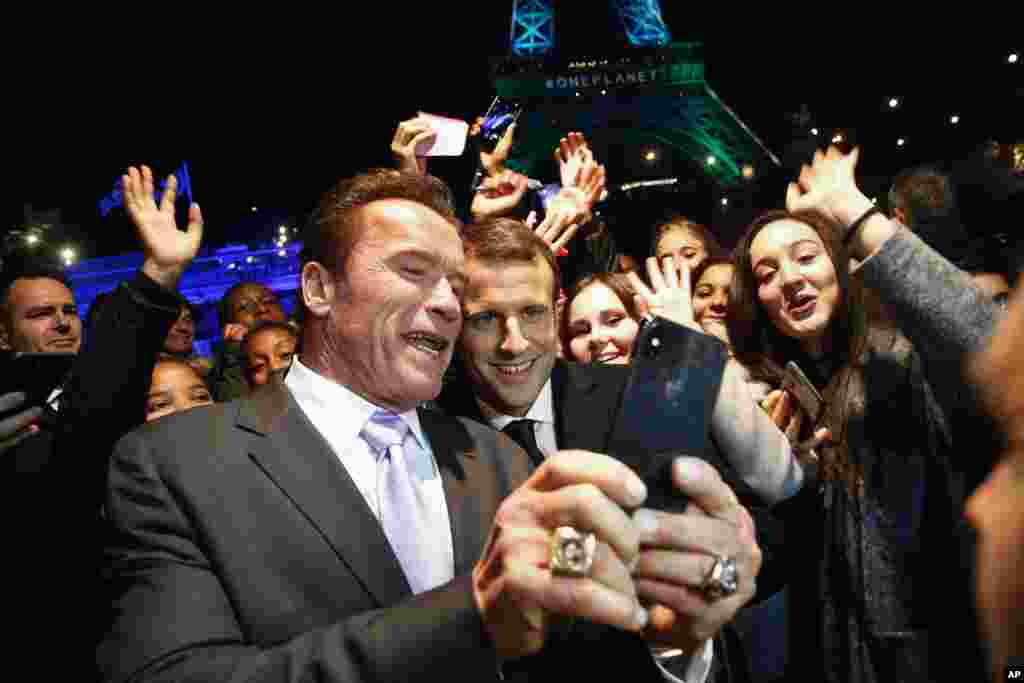 在访华前不久，法国总统马克龙与影星阿诺德&middot;施瓦辛格在参加&ldquo;一个星球&rdquo;峰会之后，在巴黎塞纳河的游船上自拍。背景是欢呼的年轻人和绿色灯光照亮的艾菲尔铁塔。（2017年12月12日）