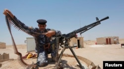 伊拉克军人在巴格达以南调整子弹带