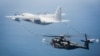 美军一架MH-53E海龙式直升机与一架KC-130加油机在维吉尼亚州诺福克海军基地附近上空进行演练。（2016年3月资料照）