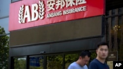 2017年6月14日，人们走过安邦保险集团驻北京办事处的入口。