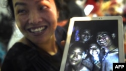 一名开心的家庭成员分享被困在山洞里的少年足球队成员照片。2018年7月2日。