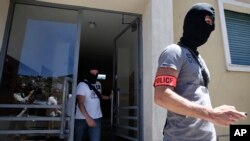 矇面的法國警方人員搜查布哈勒住所