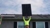 Nicholas Hartnett, chủ sở hữu của Pure Power Solar, đang lắp một tấm pin mặt trời lên mái nhà ở Frankfort, Kentucky, ngày 17/7/2023. Mỹ nhập phần lớn pin mặt trời từ Việt Nam, Malaysia, Campuchia và Thái Lan.