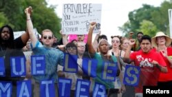 示威者在明尼苏达州圣安东尼市的警察局门前抗议黑人司机卡斯提尔被警察射杀。