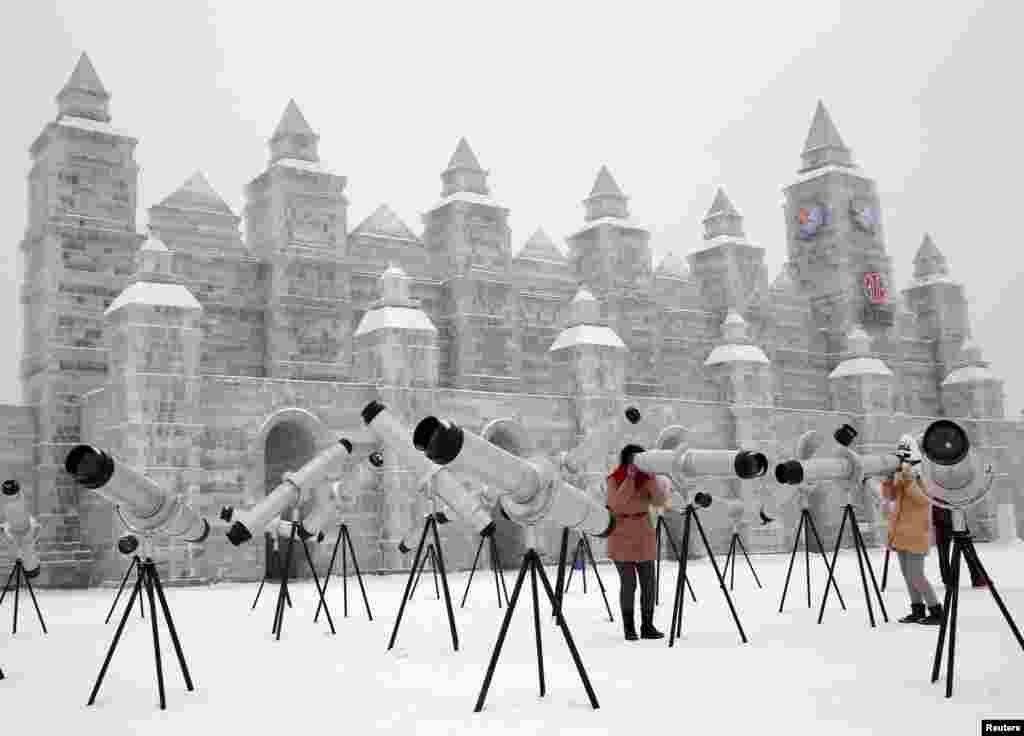 哈尔滨国际冰雪节的游客使用望远镜（2015年1月5日）