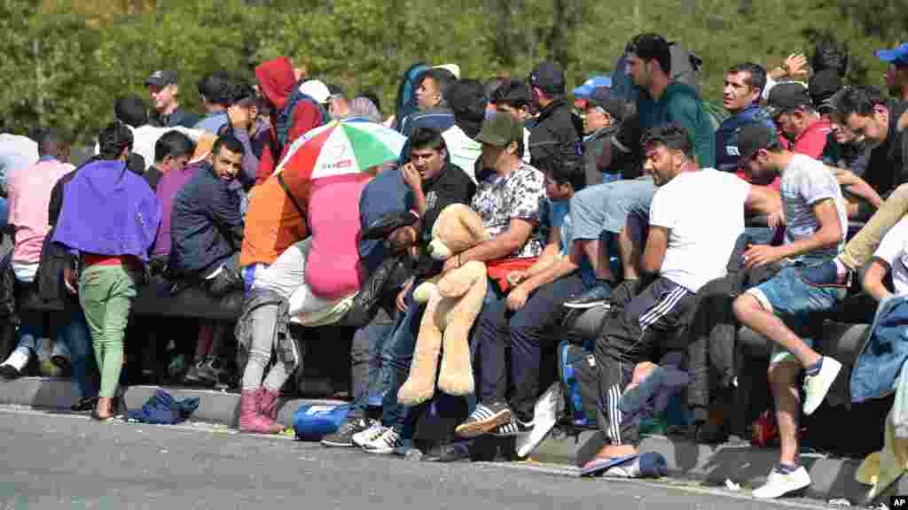 Refugees wait on a bridge after police stopped them at the border between Austria and Germany in Salzburg, Austria.