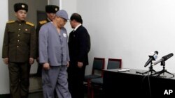 2014年1月20日,裴俊浩在看押下抵達平壤友誼醫院的記者會現場。