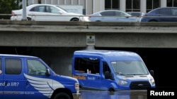 2016年1月6日加利福尼亚州圣迭戈一位机场班车司机缓缓通过洪水区。