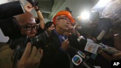 苹果日报记者韩耀庭因向胡锦涛提六四问题而被警方带走后，记者和摄影师现场围住一名香港警察(6月30日)