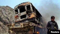 一名警察守衛著起火的北約車輛