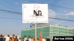 去年5月普京就职总统前夕莫斯科反政府集会中一名示威者手持宣传画。一边是原油价格，另一边疑问普京的稳定还能持续多久。(美国之音白桦拍摄)