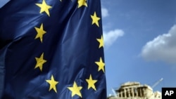 A European Union flag billows in the wind as the ruins of the 5th century BC Parthenon temple is seen in the background on the Acropolis in Athens, Greece, November 26, 2012. 