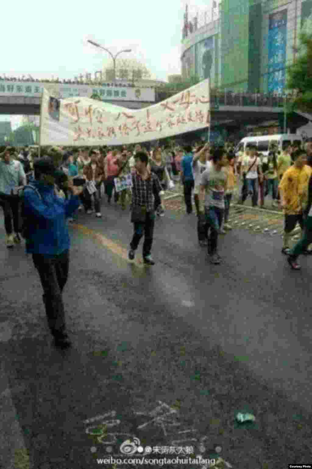 群众拉开抗议的标语在大街上游行(网民提供)