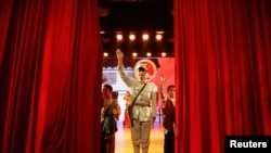 一名扮成共产党八路军的演员在山西武乡八路军文化园演出后向观众挥手。（2012年10月20日）