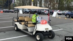 資料照片:在馬里蘭州在一家社區學院校園開設的大型新冠疫苗接種站的停車場，工作人員駕駛電瓶車接送行走不便的民眾。 (2021年4月12日)