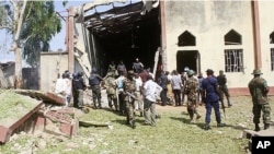 Soldiers stand guards outside St. Rita's Catholic church following a suicide bombing in Kaduna, Nigeria, October 28, 2012.