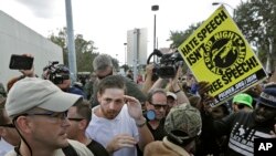 白人至上主义领袖斯派塞的一名支持者(穿白上衣者)在佛罗里达州根斯维尔与示威者发生冲突