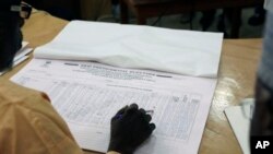 尼日利亚选举工作官员阅读地方投票结果。