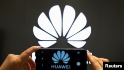 资料照：一支手机屏幕上显示的华为标识。