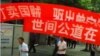 一些当地政府支持和怂恿的人在曾家镇冯建梅丈夫邓吉元的家门口打出巨幅标语(彭远文新浪微博)