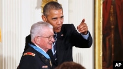 在向退役陆军中校查尔斯·凯特尔斯颁发荣誉勋章的仪式上，奥巴马与凯特尔斯开玩笑，让他面对摄像机镜头。（2016年7月18日）