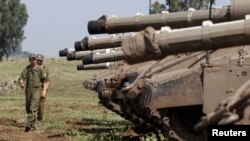 2013年5月6日以色列和敘利亞之間以色列佔領的戈蘭高地的停火線﹐以色列士兵在坦克附近走過。