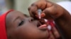 FILE - An unidentified health official administers a polio vaccine to a child in Kawo Kano, Nigeria, April. 13, 2014.