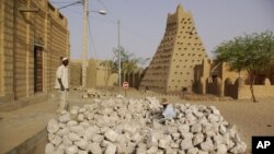 Men work alongside one of Timburktu's historic mud mosques, in Timbuktu, Mali. (file photo)