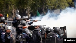 在曼谷政府大厦附近发生的冲突中，泰国防暴警察把武器对准反政府示威者。（2014年2月18日）