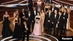 Режиссер Шон Бейкер получает «Оскар» за лучший фильм за фильм «Анора», вместе с продюсерами Самантой Куан и Алексом Коко, и победившей в номинации «Лучшая актриса в главной роли» Майки Мэдисон. Лос-Анджелес, 2 марта 2025 года. REUTERS/Карлос БаррияAWARDS-OSCARS/