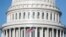 USA, Washington, The American Flag flies at the U.S. Capitol Building