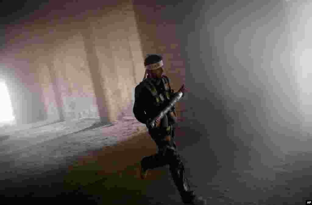 A rebel fighter prepares to fire a homemade rocket towards a Syrian air force compound on the outskirts of Aleppo, November 17, 2012. 